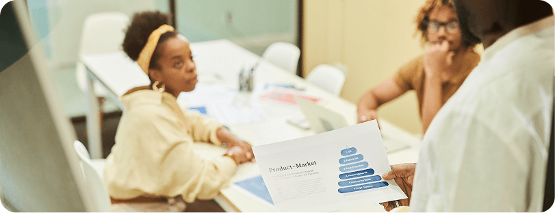Marketing colleagues reviewing a product-market pyramid document during a planning session