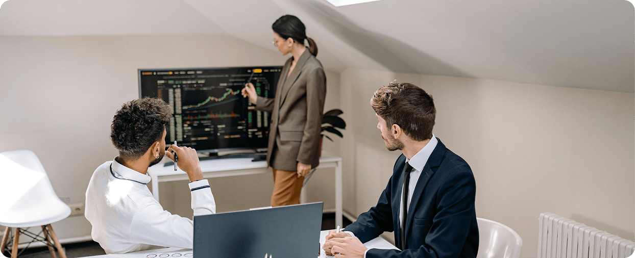 Finance team reviewing real-time market data and financial charts during a strategy discussion